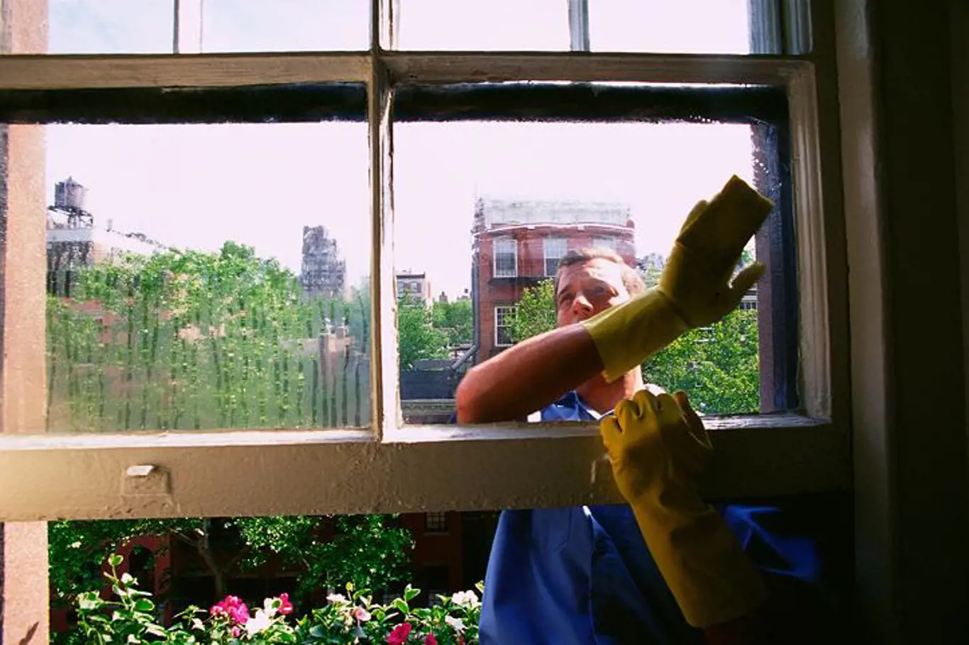 Muž myjící okno