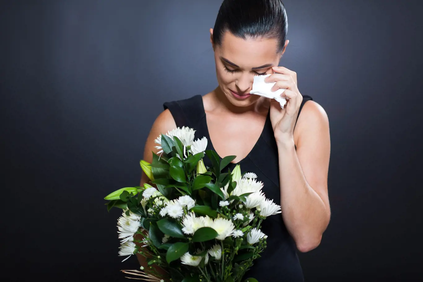 Smutná žena drží kytici a pláče