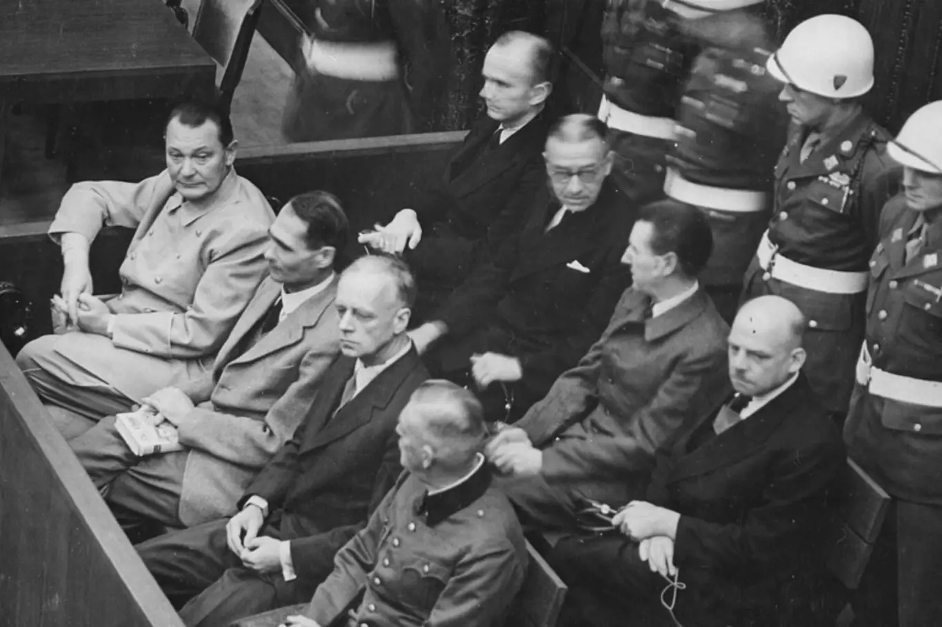 Nacističtí prominenti před soudem v Norimberku: přední řada zleva Göring, Hess, Ribbentrop a Keitel, zadní řada zleva Dönitz, Raeder, Schirach a Sauckel