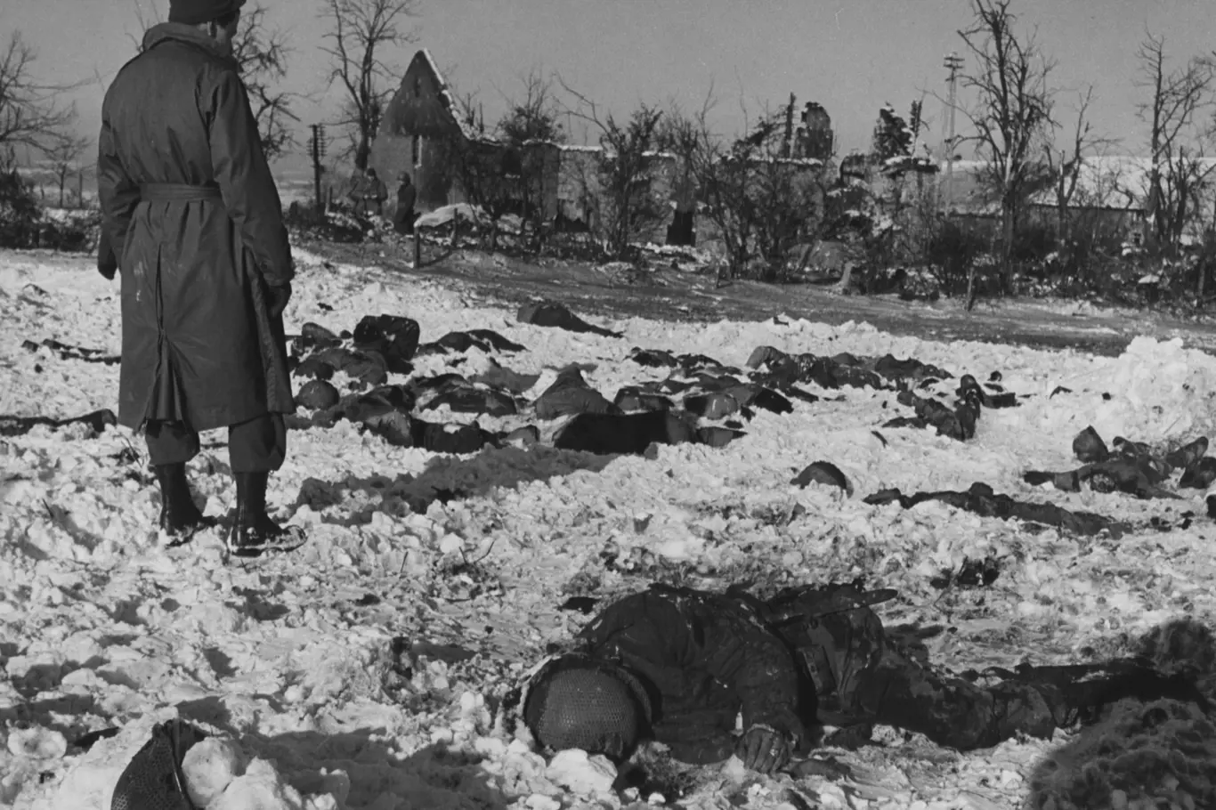 V lednu 1945 si americký voják prohlíží některé z mrtvol 84 amerických válečných zajatců, které Waffen-SS popravila 17. prosince 1944.