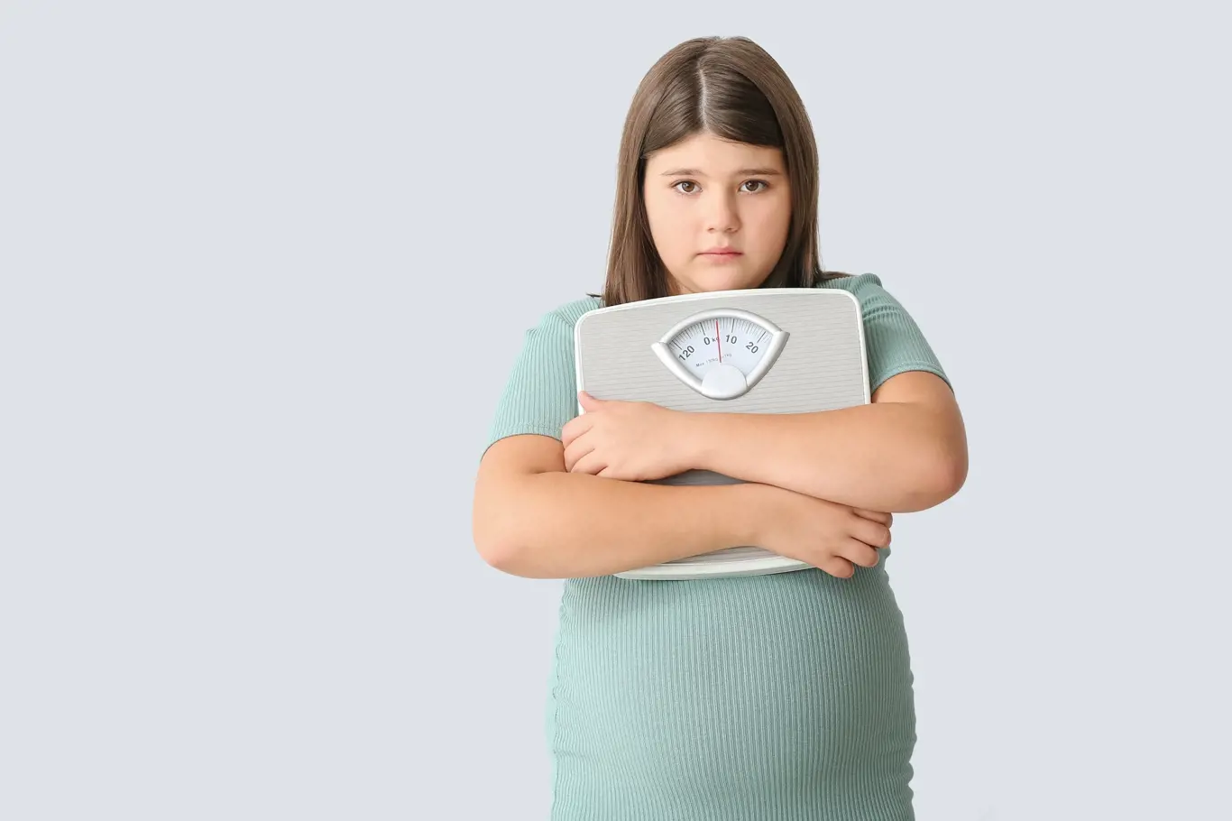 smutná obézní dívka s váhou v ruce