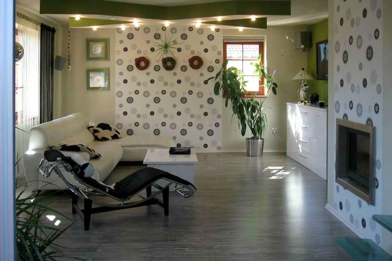 Netradičně pojatý obývací pokoj, který ovládají výrazné tapety a kříž osvětlení