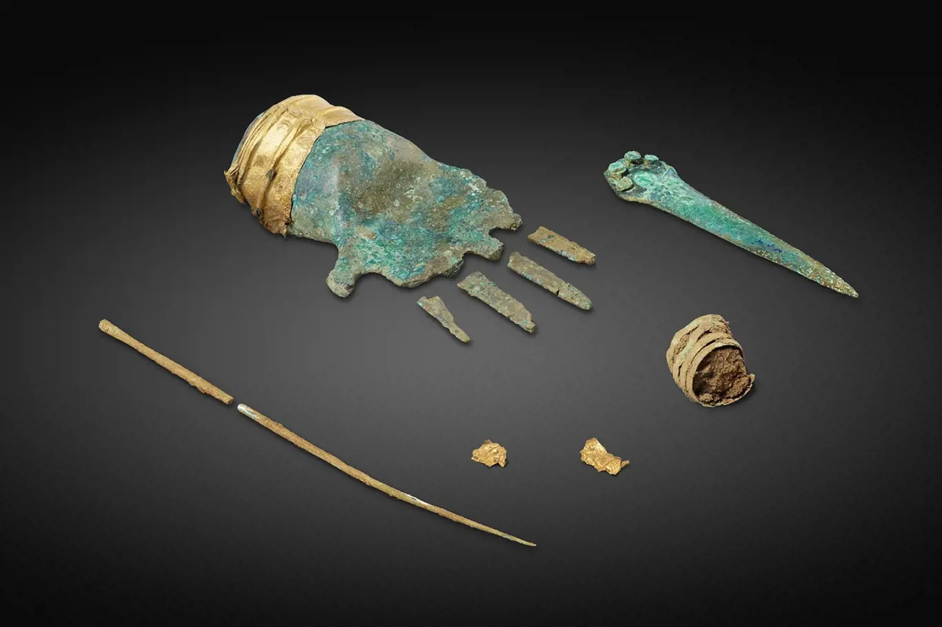 bronzová ruka a další artefakty nalezené v hrobě.