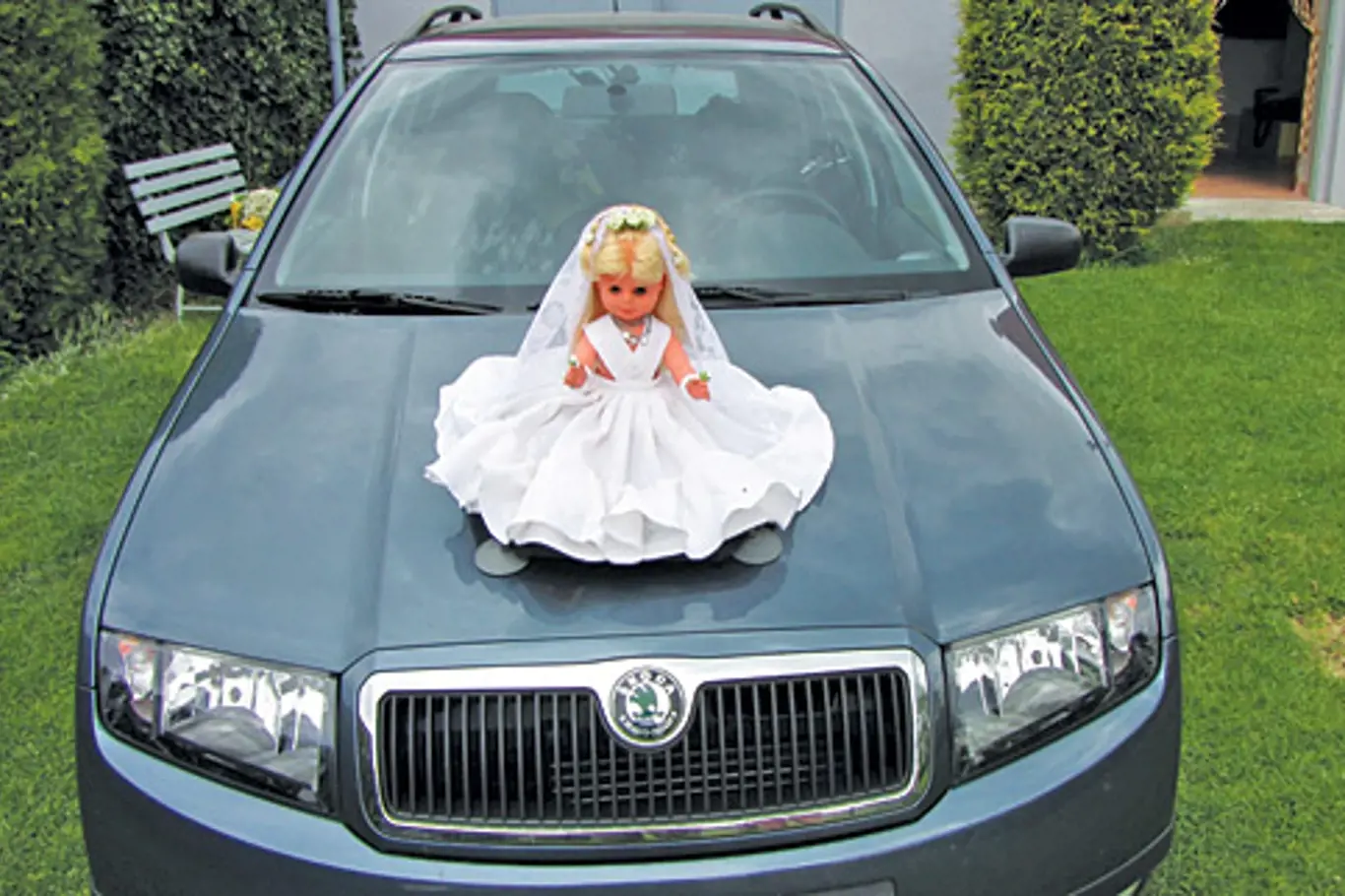 svatební panenka na kapotě auta