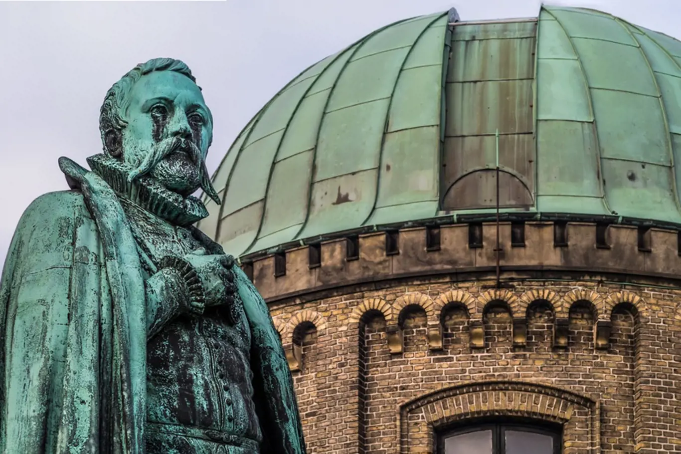 Socha Tychona Brahe před zastřešenou observatoří vedle zámku Rosenborg v dánské Kodani