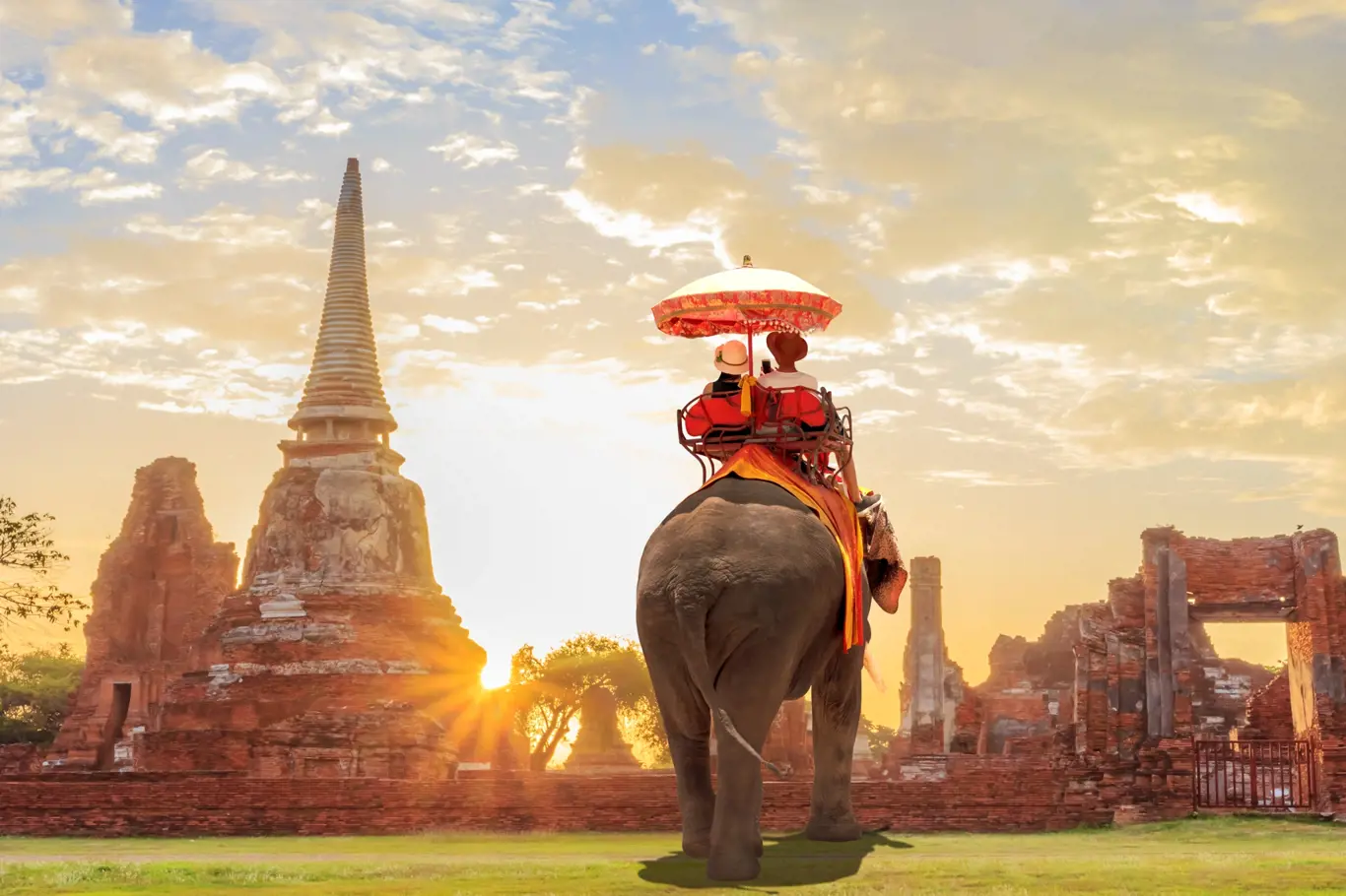 Tourists lover on an ride elephant tour of the ancient city sunset ,ayutthaya, thailand 