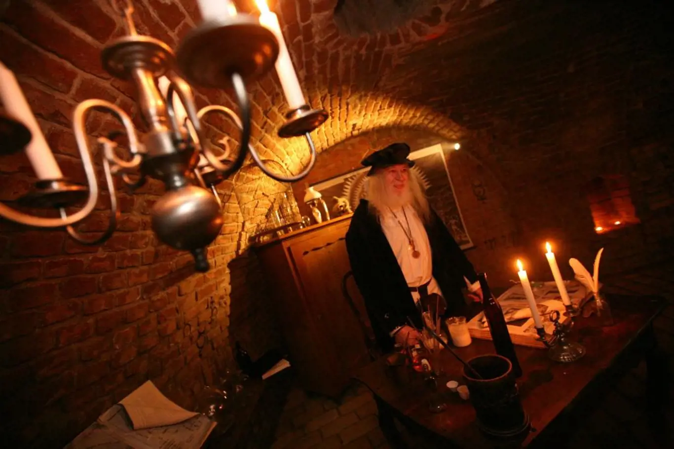 <p>Atmosféru dávných staletí dokreslují zapálené svíčky a historické předměty</p>
