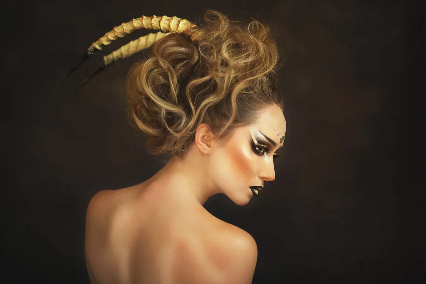 girl with horns and beautiful gothic make-up and horns in the execution of the zodiac sign Capricorn