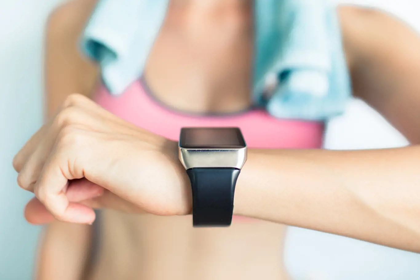 Young fit woman using smart watch at the gym. 