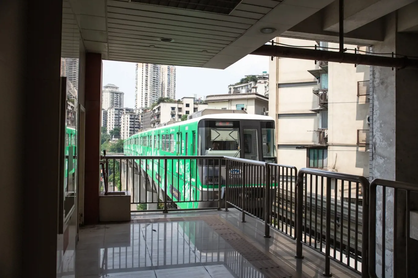 Ve městě Čchung-čching vlak projíždí panelákem.