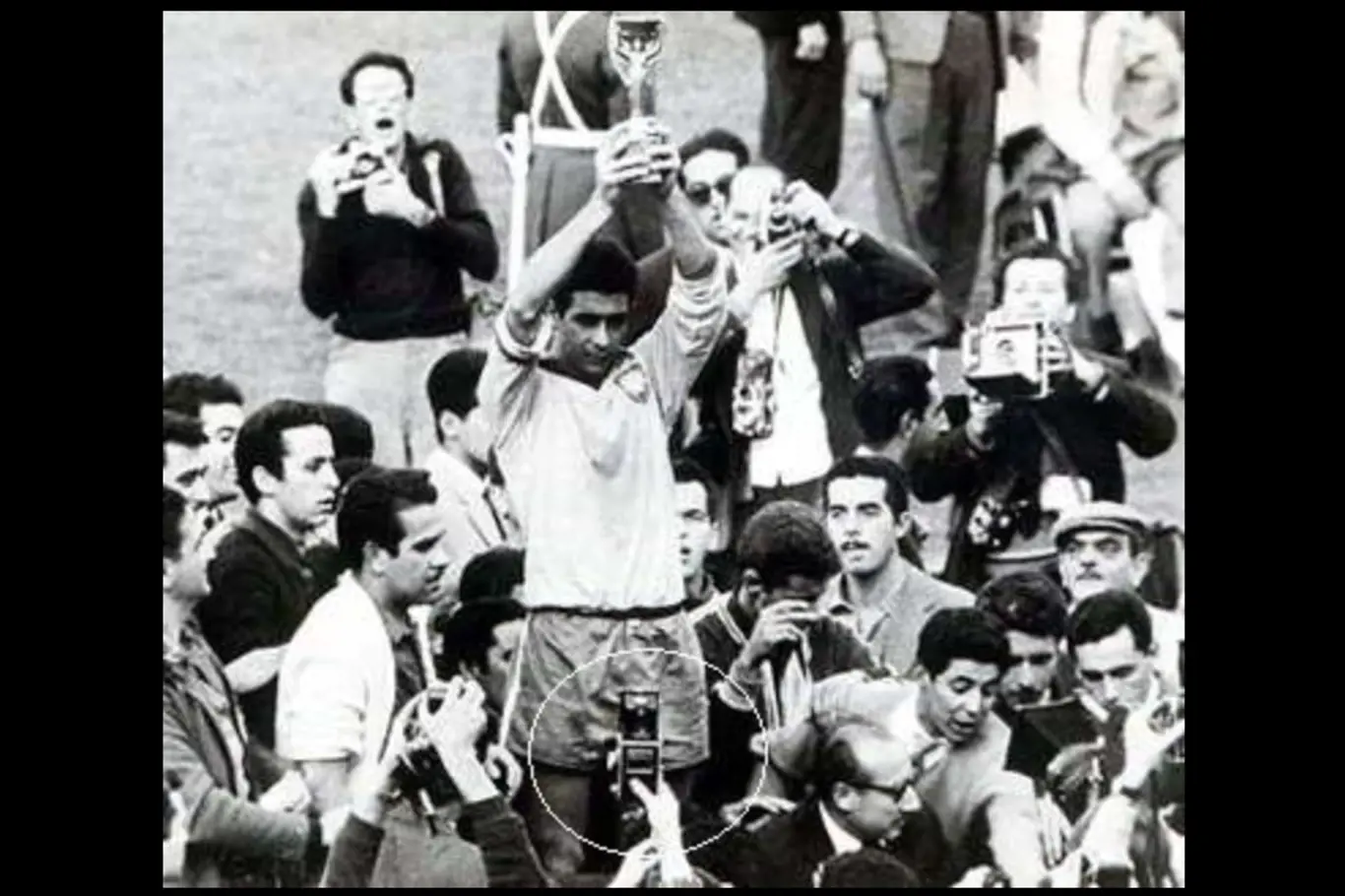 Mauro Ramos zvedá světový pohár na mistrovství světa 1962 v Chile. Co drží muž v popředí?
