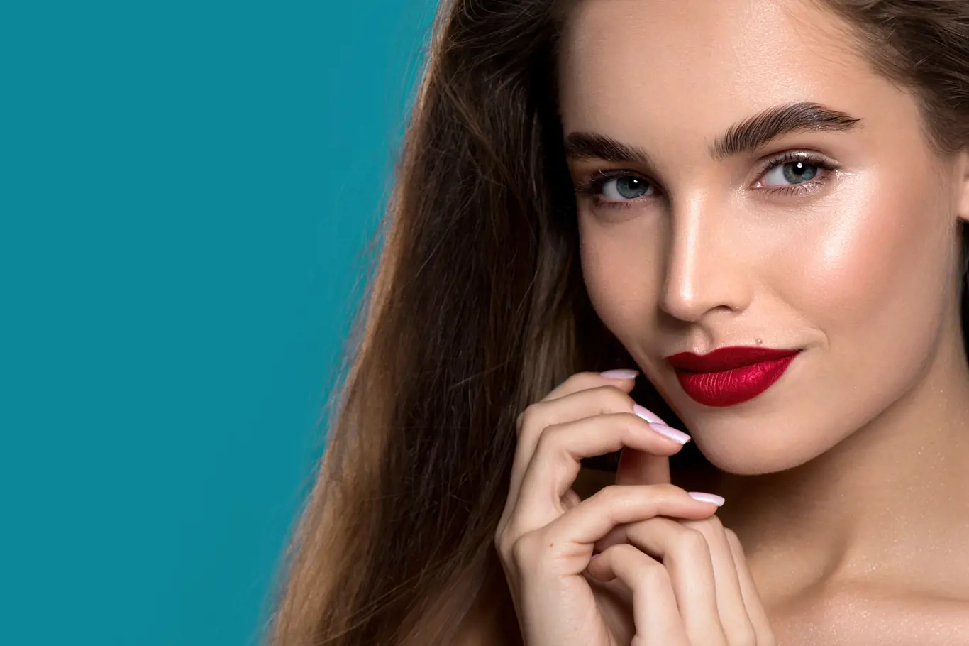 Beautiful young woman with clean perfect skin and bright red metallic lips. Portrait of beauty model with natural nude make up and long eyelashes.  Spa, skincare and wellness.