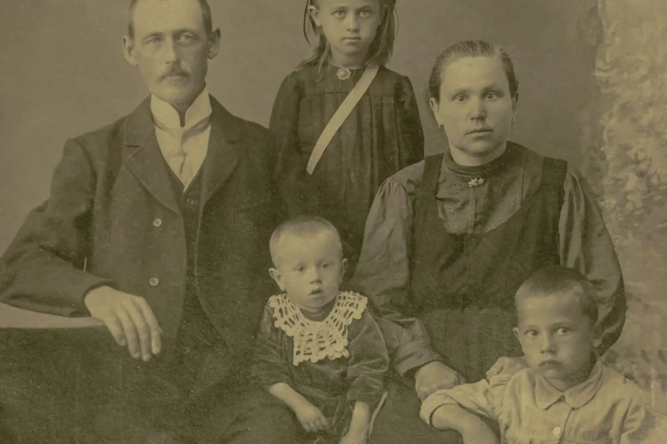 1910: Rodinný ateliérový záběr manželského páru se třemi dětmi ve studiu
