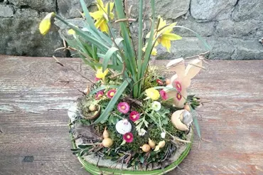 Přírodní velikonoční dekorace s květinami aranžovaná na dřevěný plát