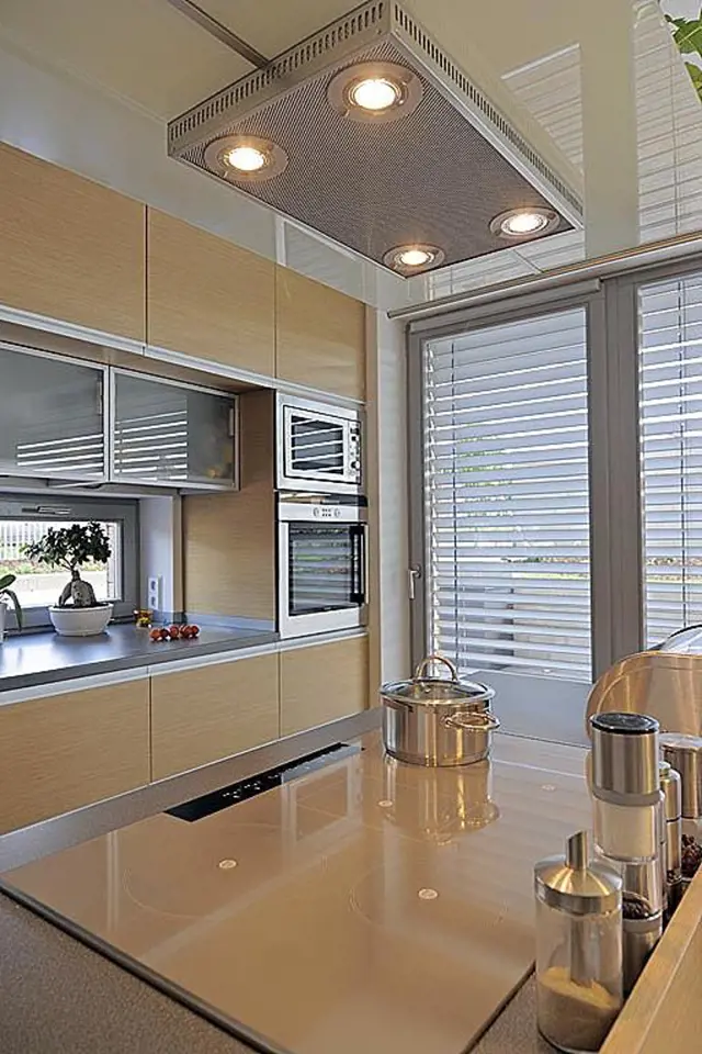 Kuchyni prosvětlují okna. Od jídelní části je kuchyňský prostor oddělen varným ostrůvkem. 