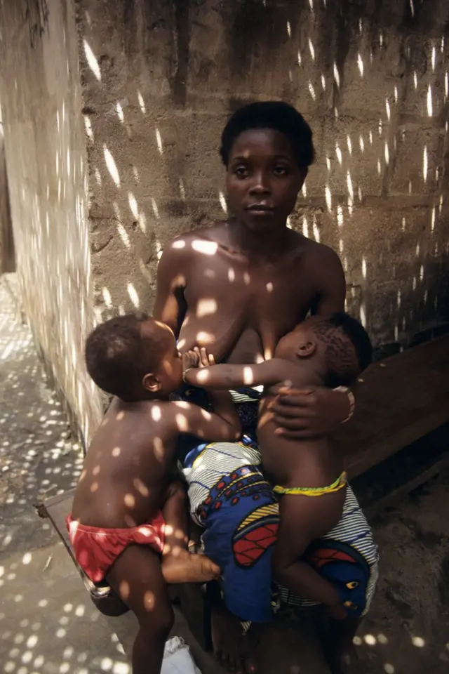 Matka (otrokyně fetiše) se dvěma dětmi před jejich domovem v ghanské provincii Volo.