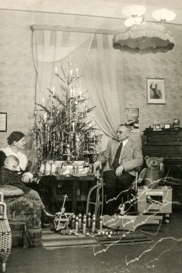 Německá rodina slaví Vánoce s portrétem Hitlera na stěně.