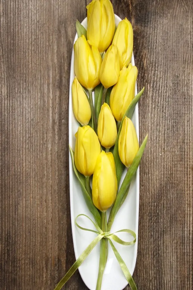 Žluté tulipány jako ozdoba svátečního stolu.