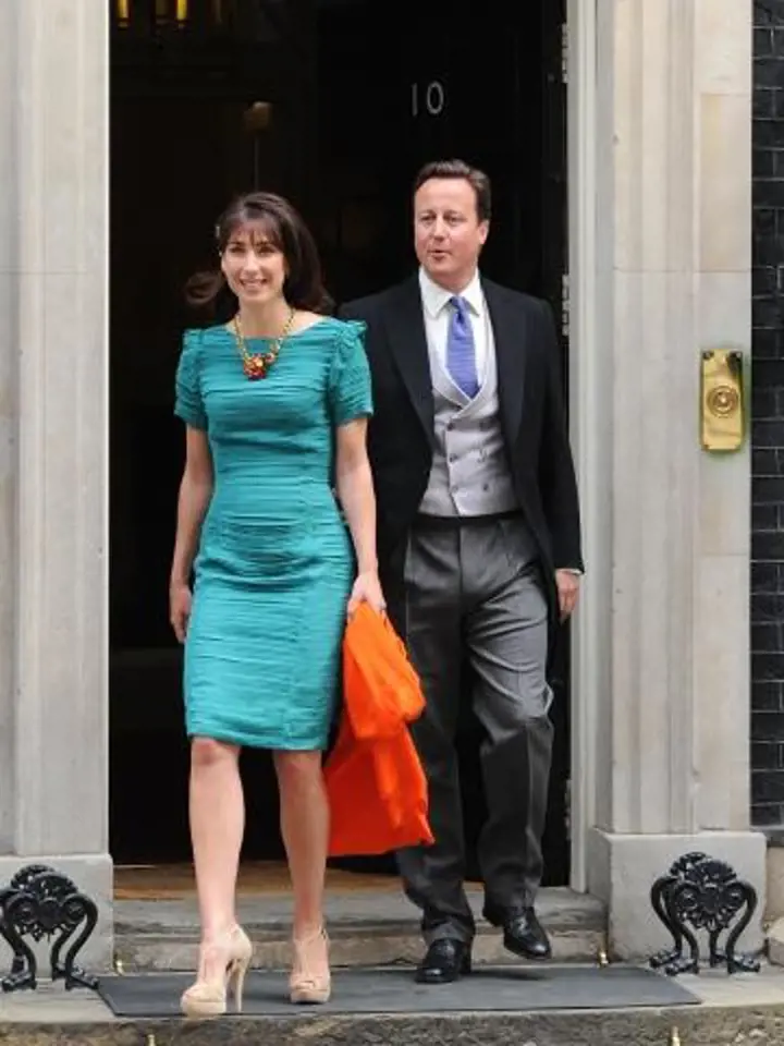 Britský premiér David Cameron s manželkou Samanthou ve smaragdových šatech s efektním žabičkováním