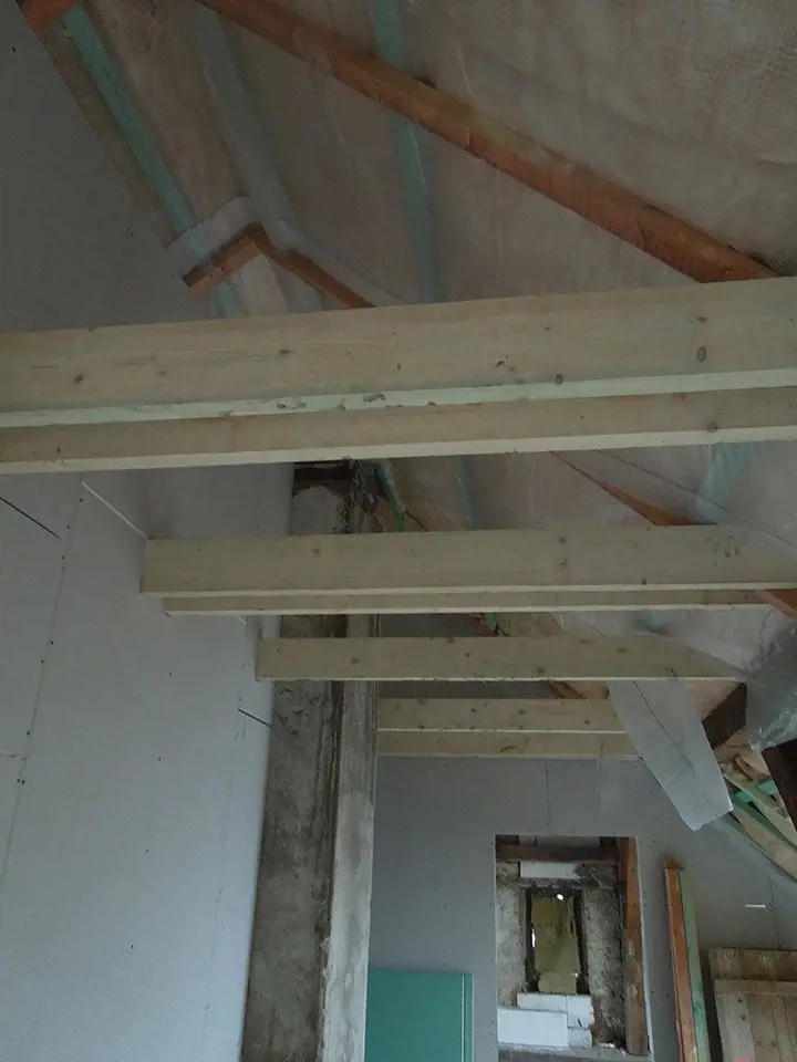 Dřevěný trámový strop byl pečlivě opravený a bude nadále vidět, tzn., nebude na něm žádný podhled. 