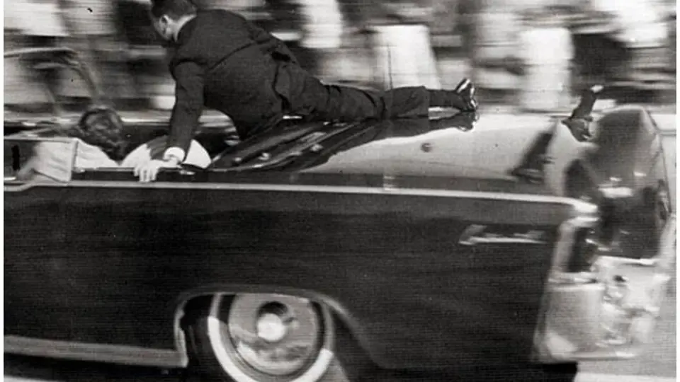 Agent Clint Hill bezprostředně po výstřelech naskočil na stupátko a zatlačil zpět do vozu Jacqueline Kennedyovou