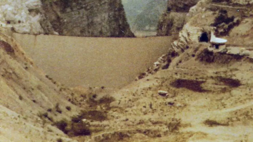 Pohled na přehradu Vajont od jezera na snímku z roku 1971. Vpravo pamětní kaple.