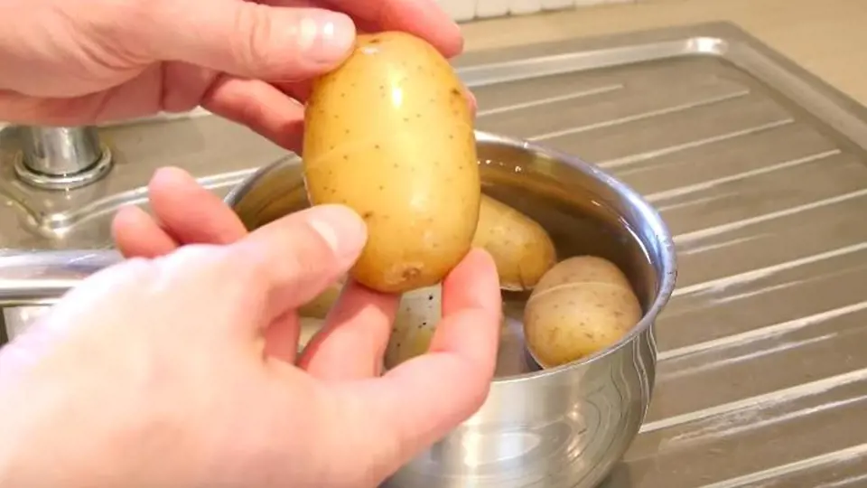 Uchopte bramboru a jemně zatlačte na slupku, ucítíte, jak vám začne pod rukama klouzat. 