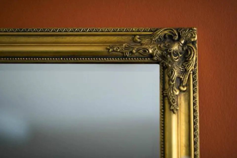 Zrcadlo ve zlatém rámu je vhodným doplňkem