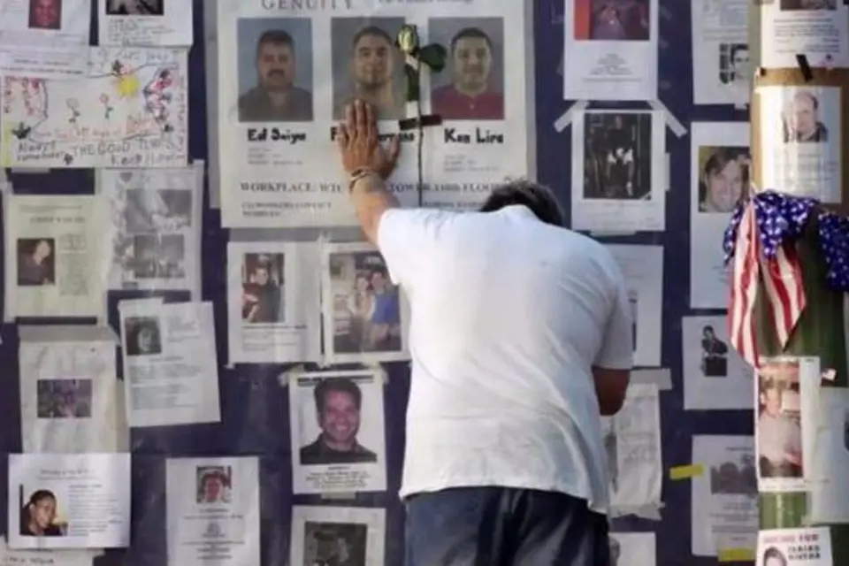 Muž truchlí u zdi s fotografiemi obětí teroristického činu z 11. 9. 2001.