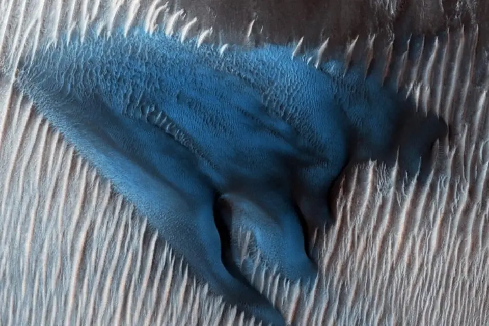 Písek se hromadí do dun na dně marsovského kráteru Lyot, jak jej na snímku zachytila sonda NASA Mars Reconnaissance Orbiter. Tato duna se ve zvýrazněných barvách zdá světle modrá, protože se její zrnka liší velikostí a složením od okolních sedimentů.