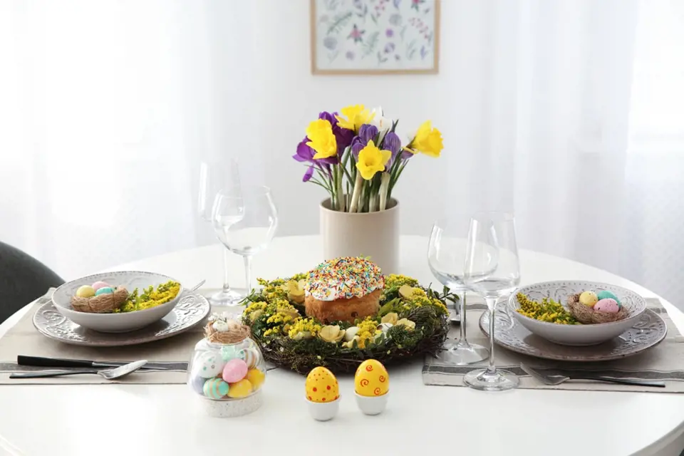 Slavnostní velikonočně vyladěná tabule s vajíčky, jarními květinami a věncem rozzáří celou místnost.