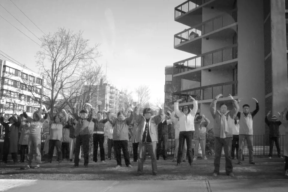 Příznivci Falun Gongu cvičením protestují před čínskou ambasádou v Torontu.
