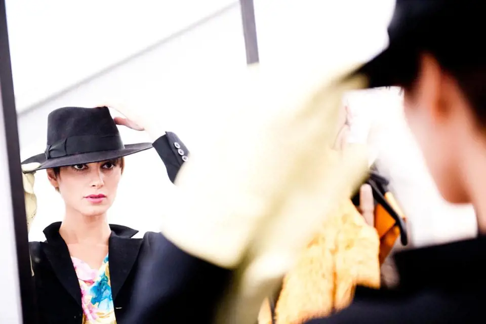 Modelka, která předvádí i pro značku Galliano, se kontroluje v zrcadle okamžik předtím, než ji spatří tisíce očí