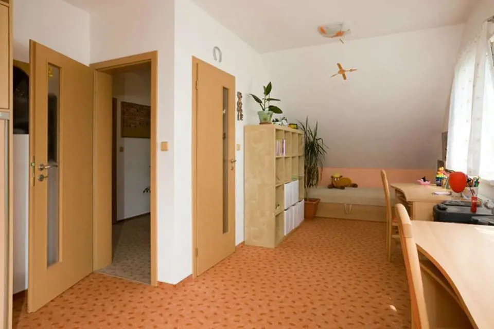 Dětský pokoj je situovaný do horního patra. Vybavený je celoplošným kobercem a dřevěným nábytkem.