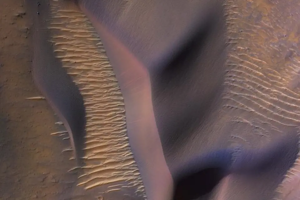 Sonda NASA Mars Reconnaisance Orbiter shlíží na svahy hory ve Valles Marineris, největším známém systému kaňonů ve sluneční soustavě. Napříč krajinou se vlní písečné duny posouvané marsovskými větry.