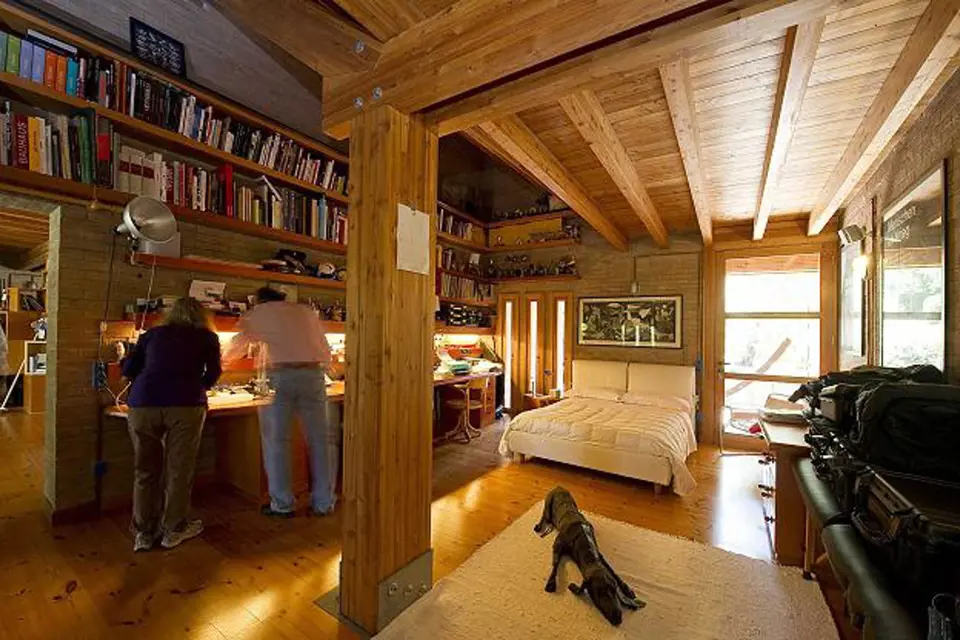 Knihovna je netypicky umístěná ve dvou pruzích nade dveřmi. V interiéru převládá dřevo.