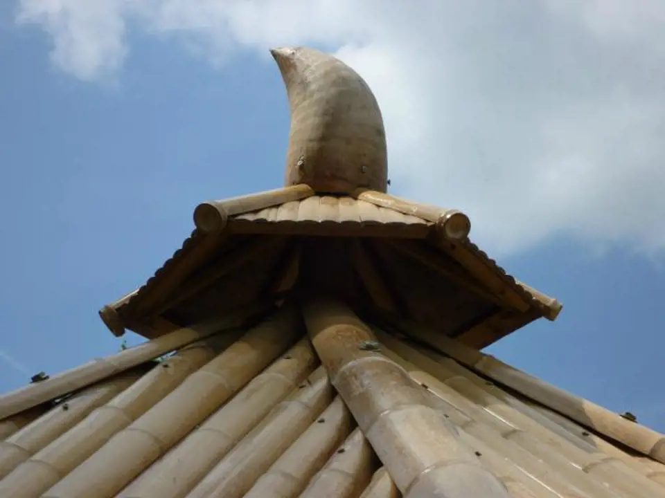 Špičku střechy zdobí kořen bambusu vypadající jako roh