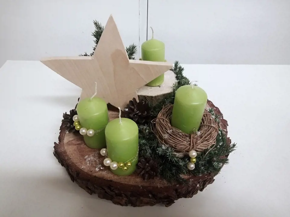 Vánoční dekorace na dřevěném plátu vyzdobená vyřezávanou hvězdou.