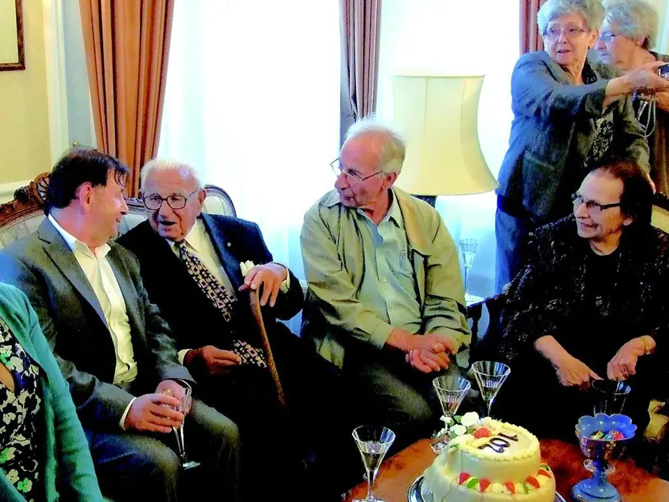 Oslava 102. narozenin sira Nicholase (uprostřed s hůlkou) v Londýně letos 19. května. Vlevo od oslavence je český velvyslanec Michael Žantovský, zcela vpravo sedí Dagmar Šímová.