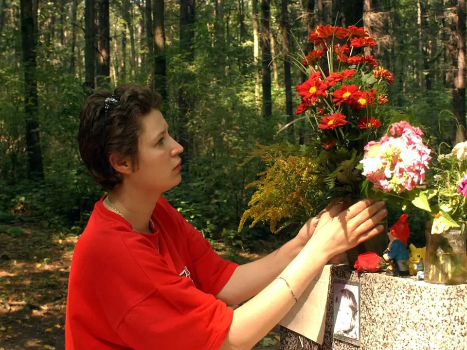Helena Čermáková pokládá květiny v lese, kam odnesla dceru
