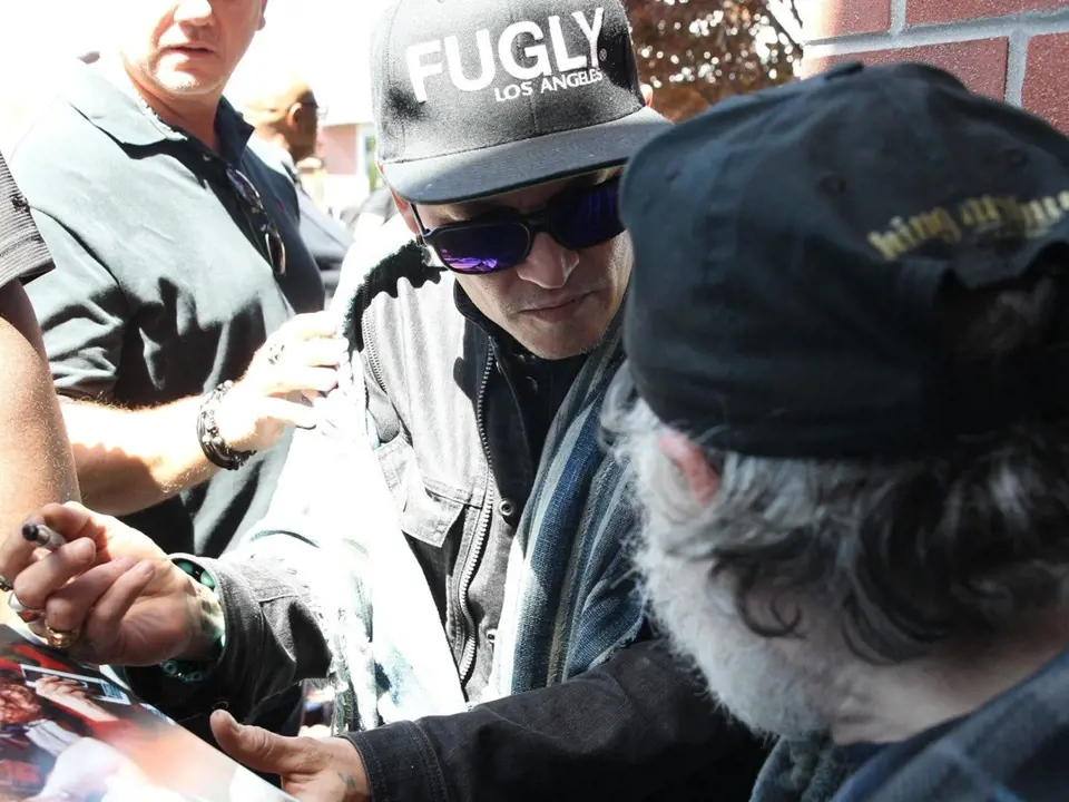 Nejnovější snímky zachycují Johnyho Deppa, kterak se podepisuje hrstce šťastných fanoušků na letišti.