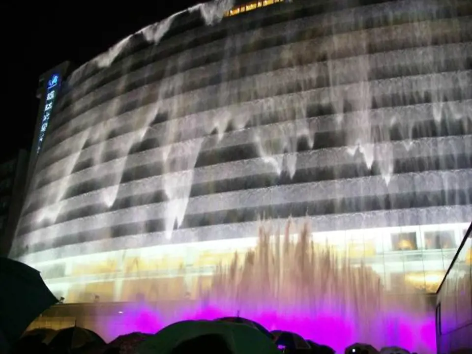Přes den hotel vypadá jako každý jiný, ale v noci také díky působivému nasvícení uchvacuje proudy vody stékajícími po jeho oknech a stěnách. Waterfall Hotel Guilin