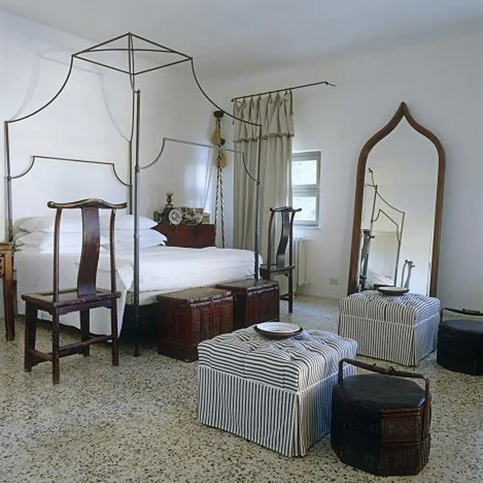 postel ve stylu 19. století v kontrastu s čínským starožitným nábytkem.