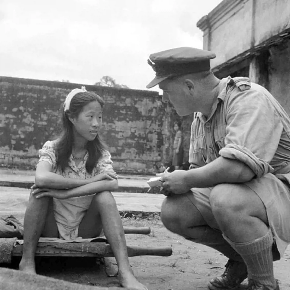 Americký voják vyslýchá osvobozenou dívku.